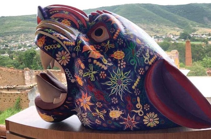 A large carved alebrije jaguar painted in fine patterns